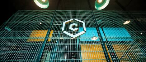 Un edificio moderno con fachada de vidrio geométrica y un logotipo hexagonal destacado.