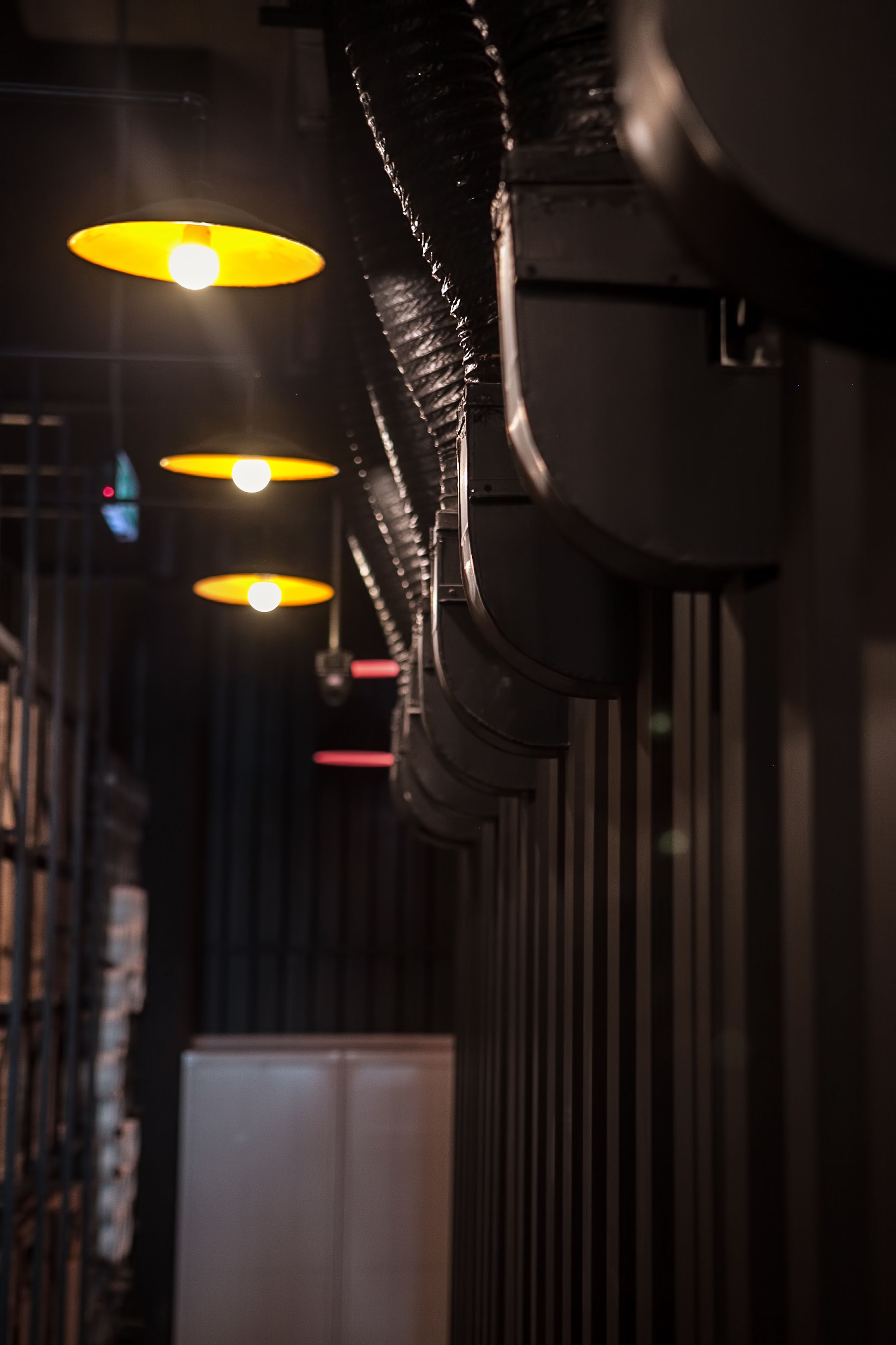A corridor with multiple hanging lights and a white cabinet in the background.