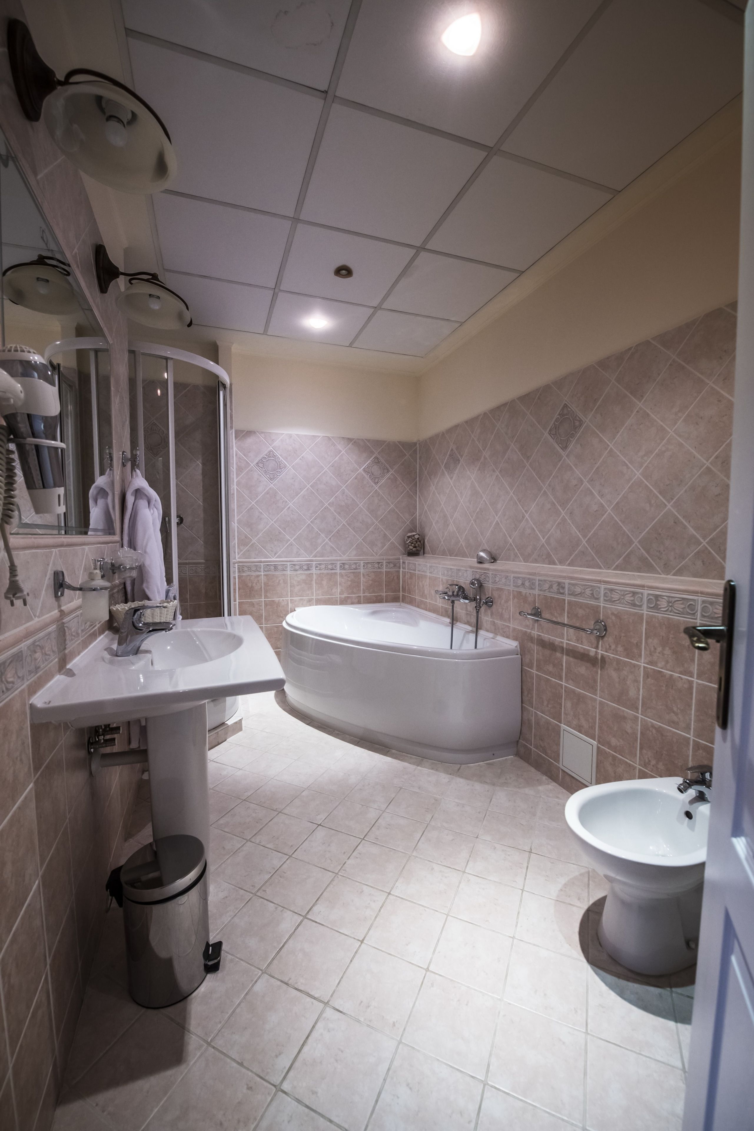 A modern bathroom with a sink, bathtub, and bidet.
