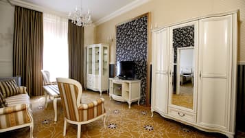 Una sala de estar con sofá, sillón, mueble para televisión y un amplio armario.