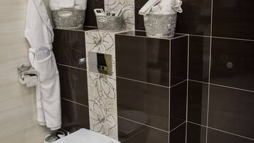 Ein modernes Badezimmer mit Toilette, Handtuchhalter und einer Wand mit floralem Dekor.