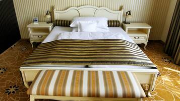 A bed with a striped bedspread, two bedside tables with lamps, and a patterned carpet.