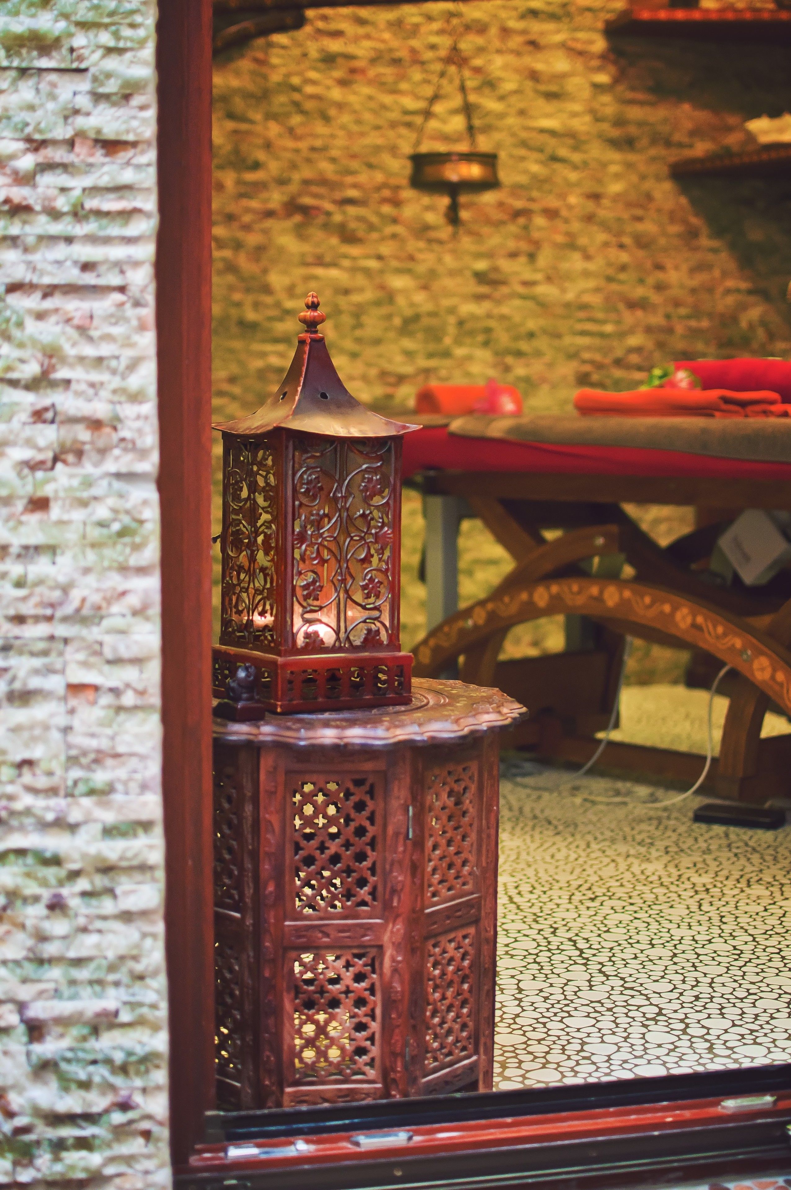 A traditional lantern with intricate designs, placed on a tiled floor.
