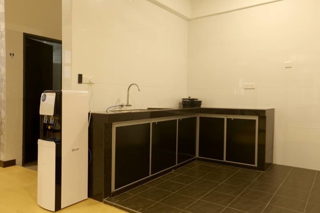 A compact kitchen with a built-in stove, a sink, and a black countertop.