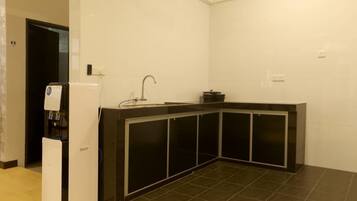A compact kitchen with a built-in stove, a sink, and a black countertop.