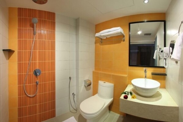 Un baño con ducha, inodoro, lavabo y espejo.