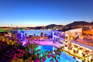 A hotel with a pool, outdoor seating, and a view of the sea. - Tropicana Beach Hotel (Bodrum)