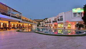 Un hotel con piscina, zona de estar exterior y una tienda.