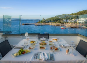 A table set for a meal with a view of a marina and boats.