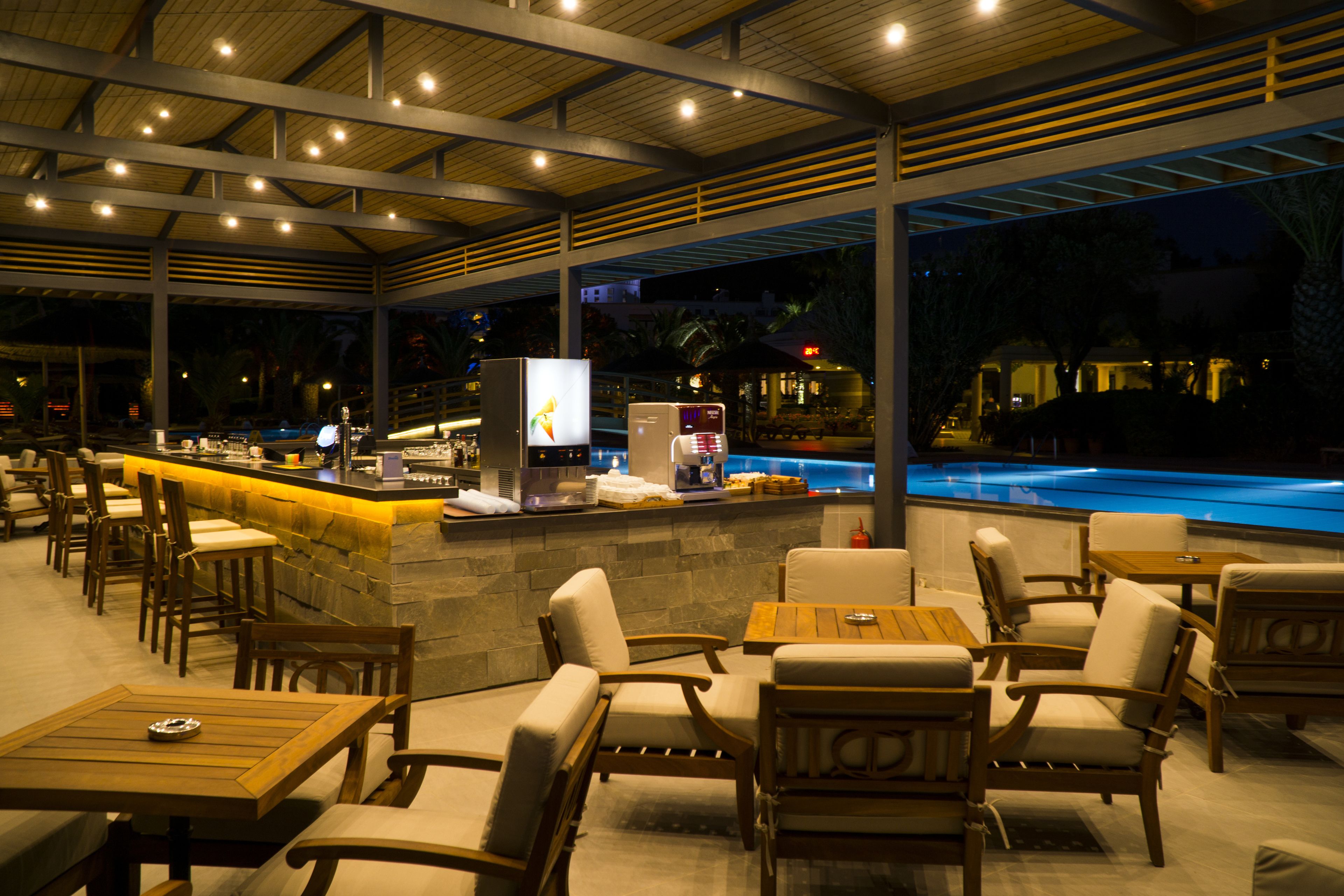An outdoor bar area with seating and a pool.