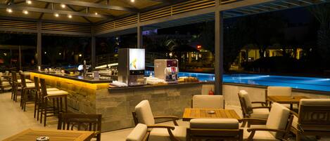 An outdoor bar area with seating and a pool.
