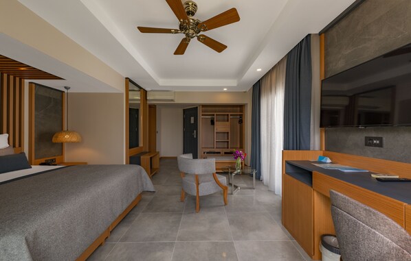 A hotel room with a bed, a desk, a chair, a ceiling fan, and a TV. - Samara Hotel Bodrum Ultra All Inclusive (Bodrum)