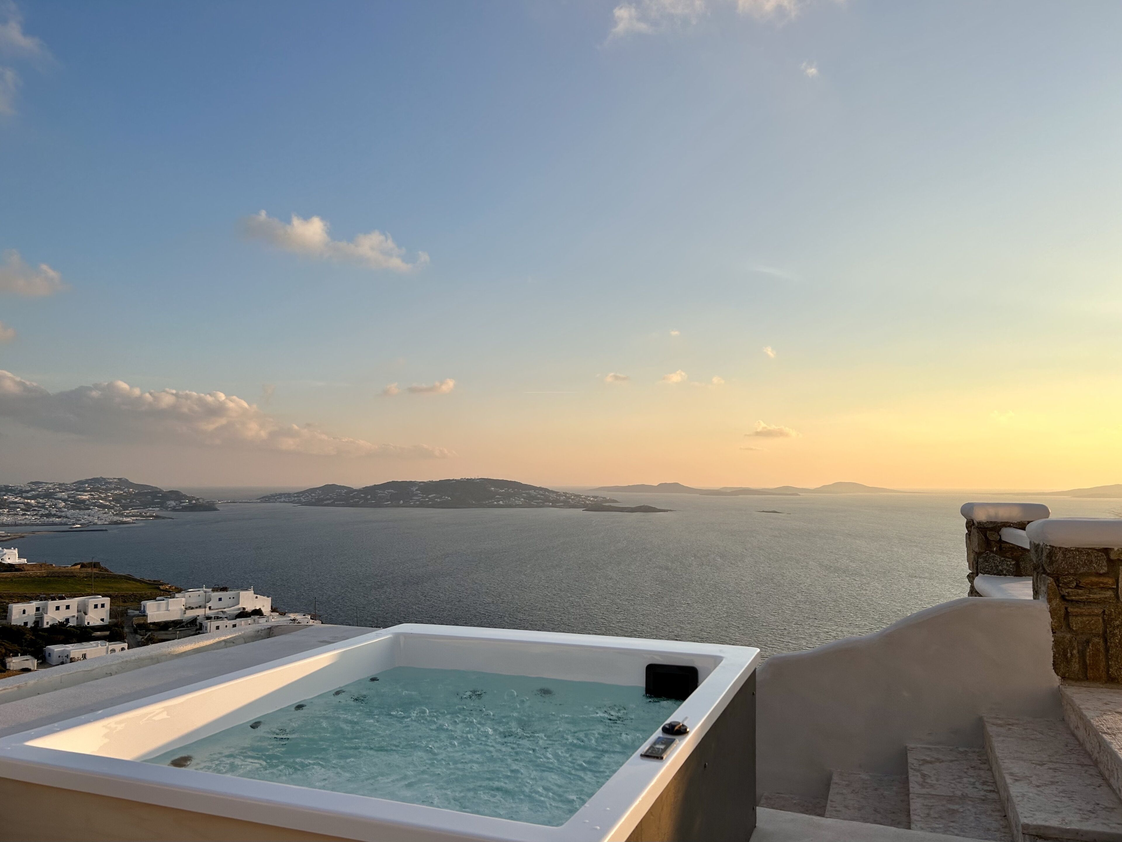 Banheira de hidromassagem com vista para a costa e céu claro.