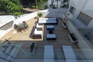 An outdoor patio with a sofa, chairs, and a table. - Pampulha Design Hotel (Belo Horizonte)