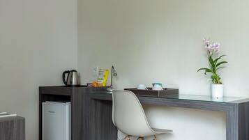 Una cocina moderna con refrigerador empotrado, cafetera y una orquídea en maceta sobre la encimera.