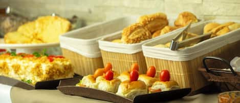 Una mesa de buffet con diversos alimentos, incluyendo pasteles y un pastel.