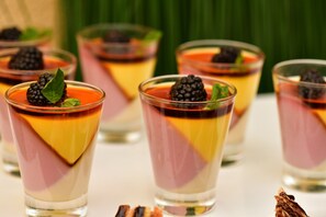 Four glasses of layered dessert with blackberries and mint leaves. - Holiday Inn Jeddah Gateway by IHG (Jeddah)