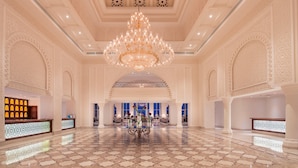 A spacious lobby with a large chandelier, intricate wall designs, and a reception desk. - Baron Palace Sahl Hasheesh (Sahl Hasheeh)