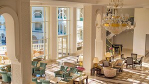 A spacious lobby with a high ceiling, large windows, and a grand chandelier. - Baron Palace Sahl Hasheesh (Sahl Hasheeh)