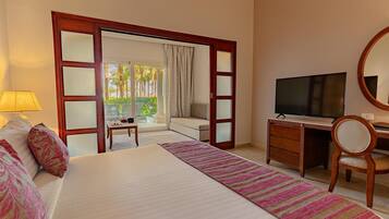 Ein Hotelzimmer mit Bett, Schreibtisch, Fernseher und Blick ins Freie.