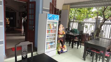 Enjoy a refreshing drink from the vending machine in this dining area, surrounded by a balcony with a view of the trees.
