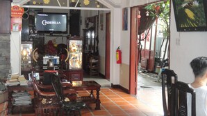 A living room with a television, wooden furniture, and a tiled floor. - Homestay Countryside (Da Nang)