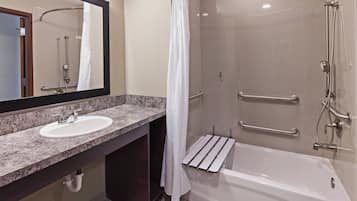 A modern bathroom with a sink, mirror, shower, and bathtub.