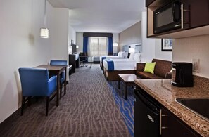 A hotel room with a dining area, a kitchenette, a bed, and a seating area. - Holiday Inn Express & Suites Glenpool-Tulsa South by IHG (Glenpool)