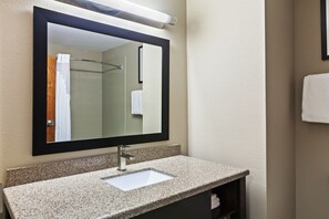 A bathroom with a granite countertop, a white sink, and a large mirror. - Holiday Inn Express & Suites Glenpool-Tulsa South by IHG (Glenpool)