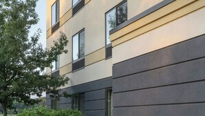 Een terras met buitenmeubilair van modern riet, omringd door een vuurkuil.