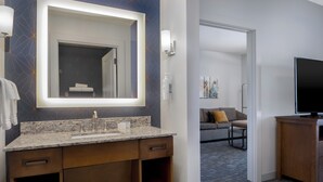A modern bathroom with a large mirror, granite countertop, and wooden cabinetry. - Homewood Suites By Hilton Billings, MT (Billings)