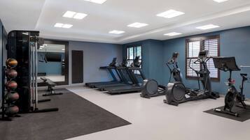 A gym with treadmills, stationary bikes, and a weight machine.