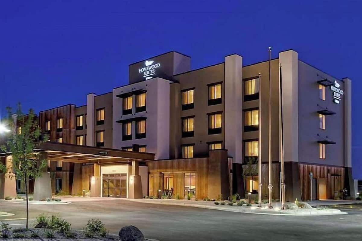 Een modern hotel met een opvallende ingang, meerdere verdiepingen en een goed verlichte gevel.