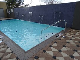Una piscina al aire libre, sombrillas, tumbonas