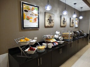 A buffet setup with various food items and a menu display. - Holiday Inn Covington by IHG (Covington)