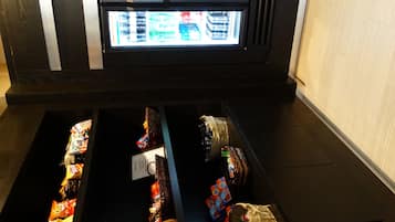 A storage compartment with various food items and a freezer above it.