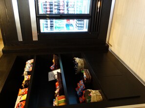 Compartimento com diversos alimentos e um freezer acima.