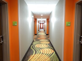 Pasillo de hotel con puertas numeradas 512 y 515, cubierto con un diseño de alfombra estampado.