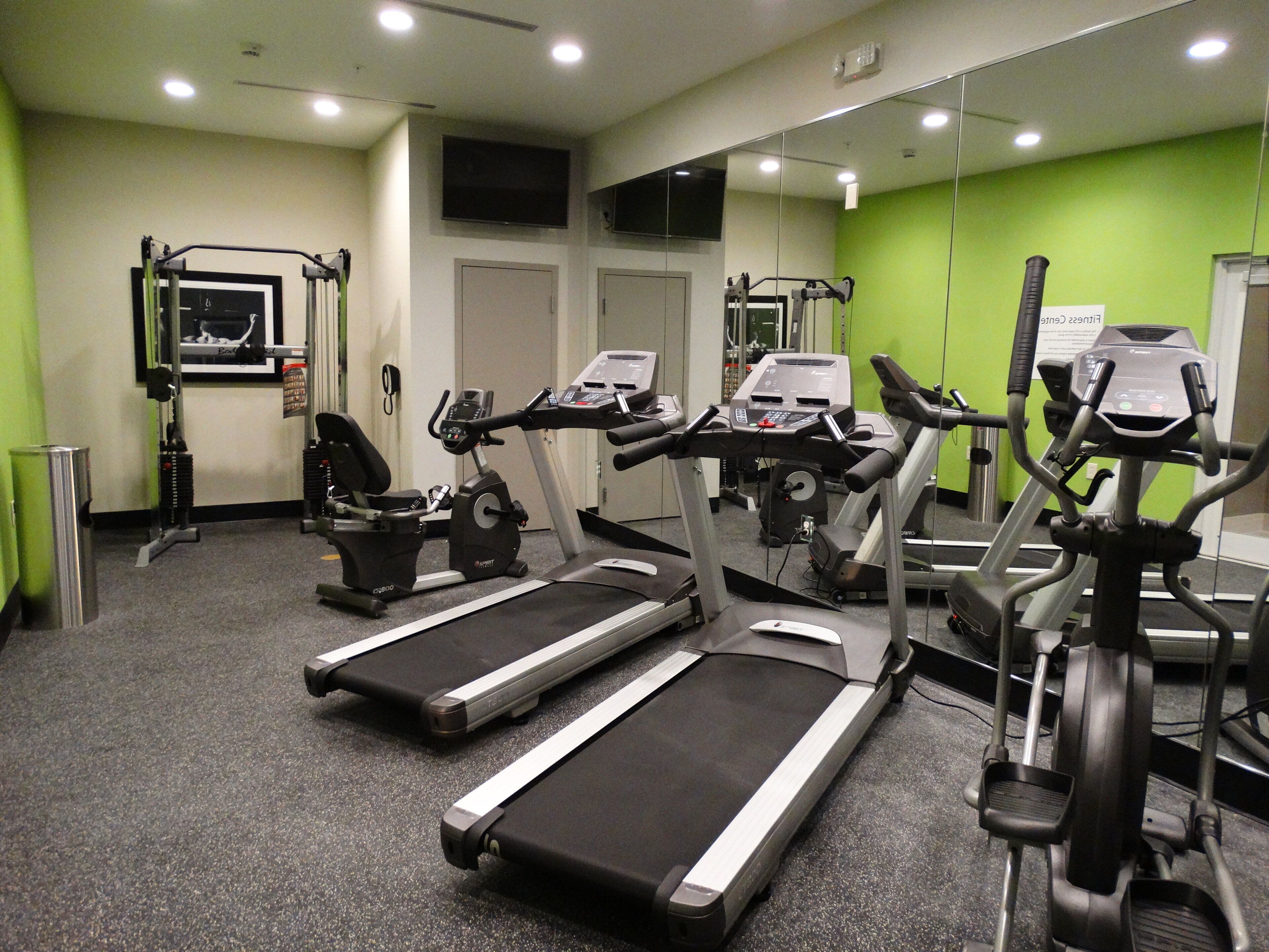 A gym with treadmills, stationary bikes, and weight machines.