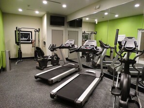A gym with treadmills, stationary bikes, and weight machines.