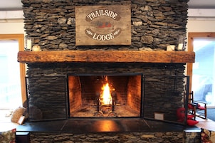 Una chimenea de piedra con un letrero arriba que dice "Trailside Lodge".