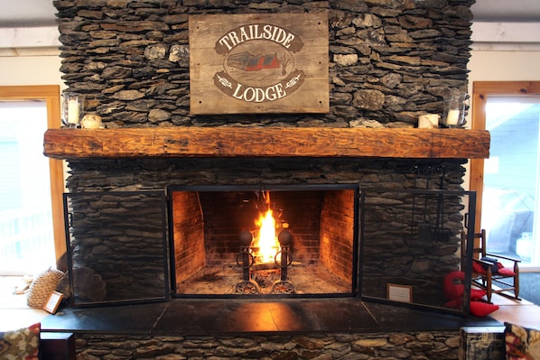 Una chimenea de piedra con un letrero arriba que dice "Trailside Lodge".
