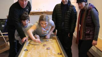 Enjoy a game of shuffleboard in our indoor recreational area, featuring a rectangular table with metal scoring cups.
