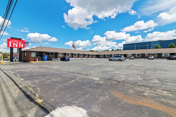 A motel with a large parking lot, a Pizza Inn sign, and a blue building in the background.