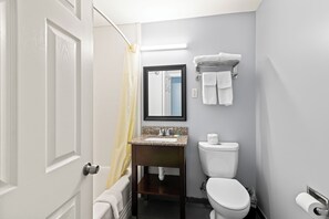 Een bad/douchecombinatie, een haardroger, handdoeken