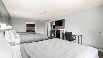 Een hotelkamer met twee bedden, een bureau, een stoel, een televisie en een kledingkast.