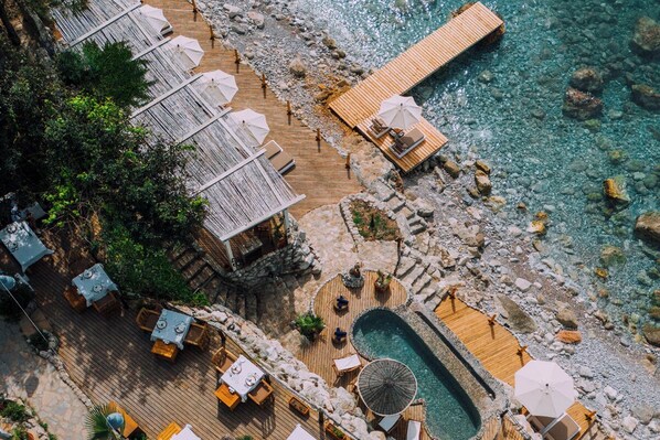 An aerial view of a resort with a wooden deck, outdoor seating, and a pool. - Nautical Hotel Adults Only  (Fethiye)