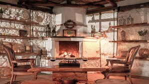 Ein rustikales Interieur mit Kamin, Holzmöbeln und Regalen mit Dekoration.