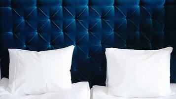 A bed with a tufted headboard and white pillows.