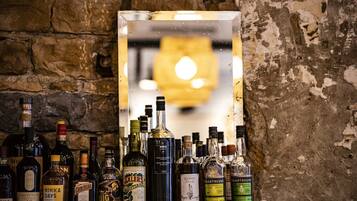 Un bar con varias botellas de licor exhibidas frente a una pared de piedra.